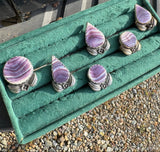 Set of purple stone rings in a green jewelry box on a textured surface