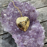Gold heart-shaped pendant on a purple amethyst crystal rock