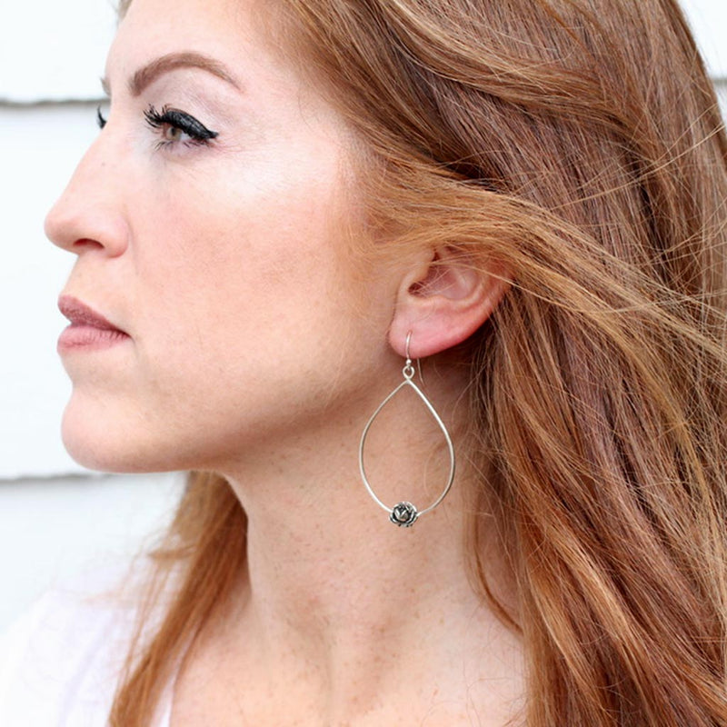 side profile of a beautiful auburn colored hair lady with rose earring