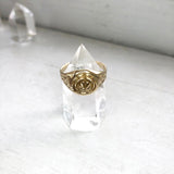 yellow brass signet ring with rose displayed on clear crystal