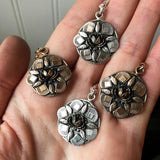 hand full of floral pendant necklaces