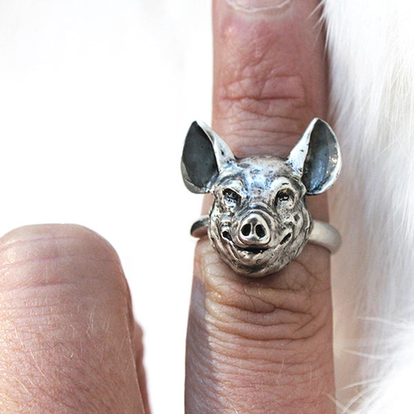 silver pig head ring on a finger